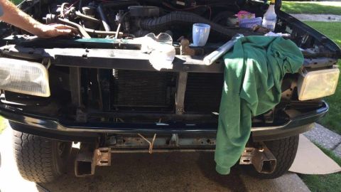 1995 Ford Bronco - Front view of a green Ford Bronco with the hood open, revealing the engine and radiator assembly.