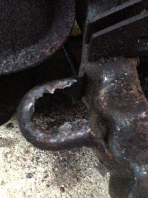 1995 Ford Bronco - This close-up shows a damaged, rusted metal bracket with a hole, likely a vehicle part.