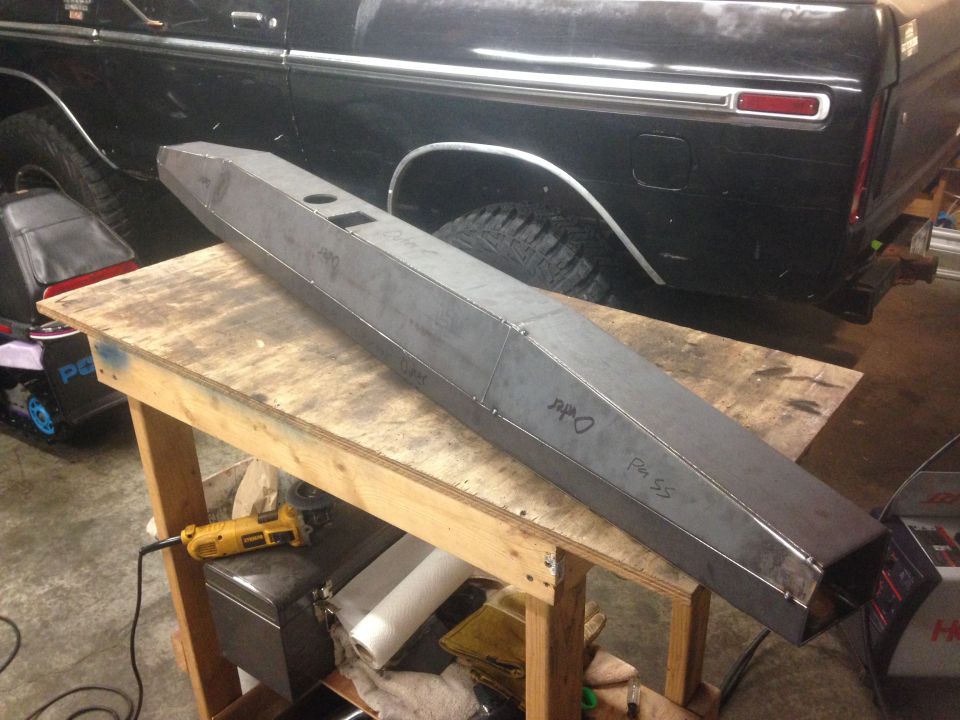 Custom steel bumper on workbench in front of black Ford Bronco