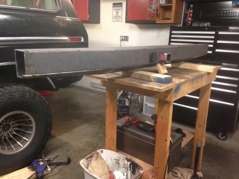 1979 Ford Bronco - A custom metal bumper is shown being fabricated and prepared for installation on a black 1979 Ford Bronco. The bumper is resting on a woode…