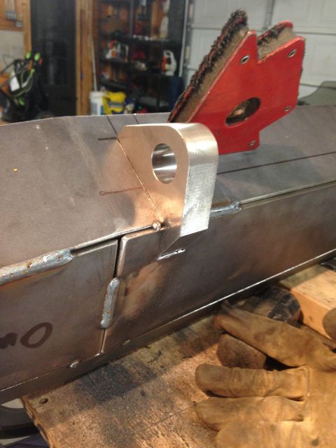 1979 Ford Bronco - A close-up view of metal fabrication work, likely in a garage or workshop setting. The focus is on a metal bracket being welded onto a larg…