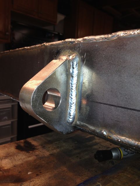 1979 Ford Bronco - A close-up view shows a welded metal bracket attached to a large metal beam. The bracket has a circular opening and the welds are clearly v…