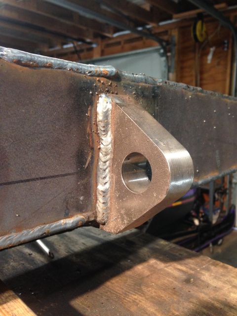 1979 Ford Bronco - A close-up view shows a heavy-duty metal bracket with a circular hole, welded onto a thick steel beam. The weld appears rough and industria…