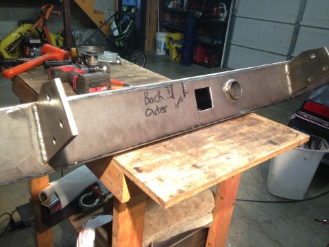 1979 Ford Bronco - A fabricated steel bumper or frame component is shown on a workbench, with hand-written "Back 31 Outer" text on its surface. Tools includin…