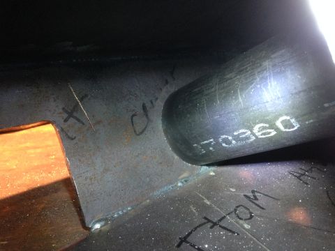1979 Ford Bronco - A close-up view of metal components with handwritten markings and a serial number stamped on a pipe. The scene appears to be part of a vehi…