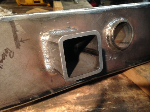 1979 Ford Bronco - A close-up view of a metal fabrication project, likely a trailer hitch receiver, showing a square tube welded onto a larger metal plate. Th…