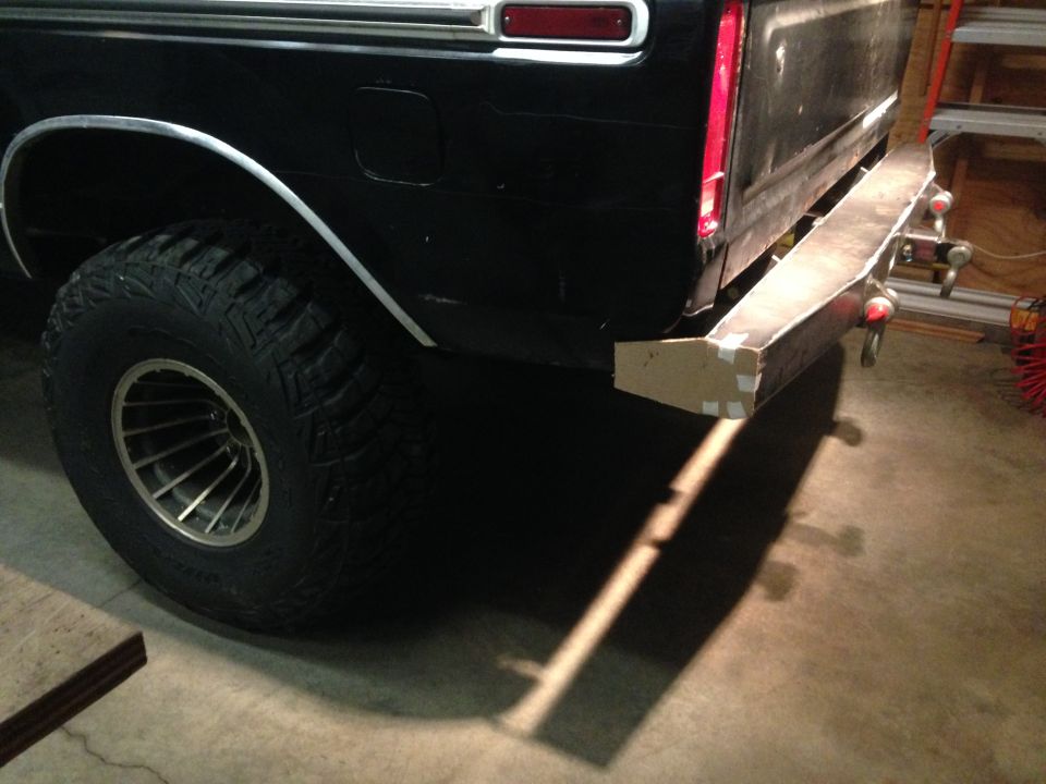 Black pickup truck rear driver's side with off-road tire and custom bumper