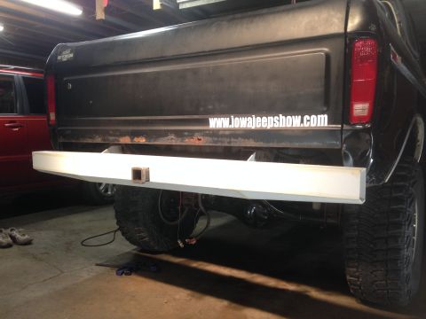 1979 Ford Bronco - The rear of a black Ford Bronco with a white custom bumper installed. A website address is visible on the tailgate.
