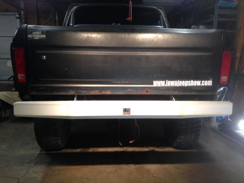 1979 Ford Bronco - The rear of a black Ford pickup truck is shown with a custom white bumper. A sticker on the tailgate reads "www.iowajeepshow.com".