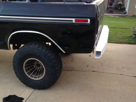 1979 Ford Bronco - Close-up of a 1979 Ford Bronco's rear section, showing the tire and a custom bumper addition.