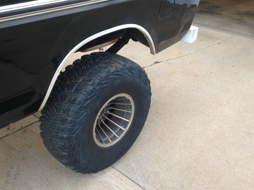 Rear wheel and fender flare of a black SUV with large off-road tires