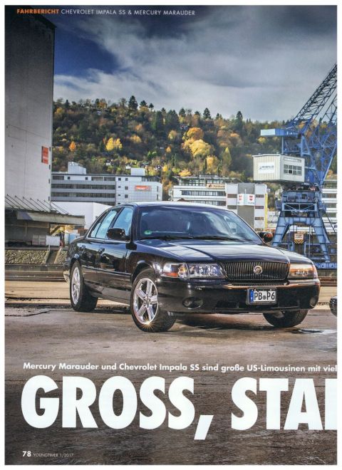 2003 Mercury Marauder - A black 2003 Mercury Marauder is shown parked in an industrial area with cranes and buildings visible.