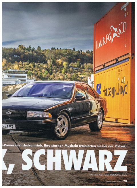 2003 Mercury Marauder - A black sedan with gold trim is parked next to shipping containers under a cloudy sky.