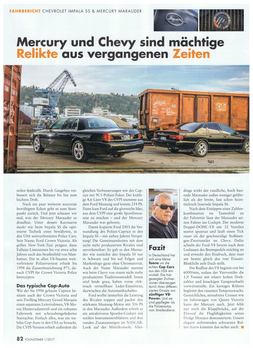 Black Mercury Marauder and a black Chevrolet Impala SS parked near a train car and crane
