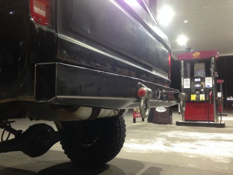 1979 Ford Bronco - Custom rear bumper with tow hooks on a 1979 Ford Bronco at a gas station.