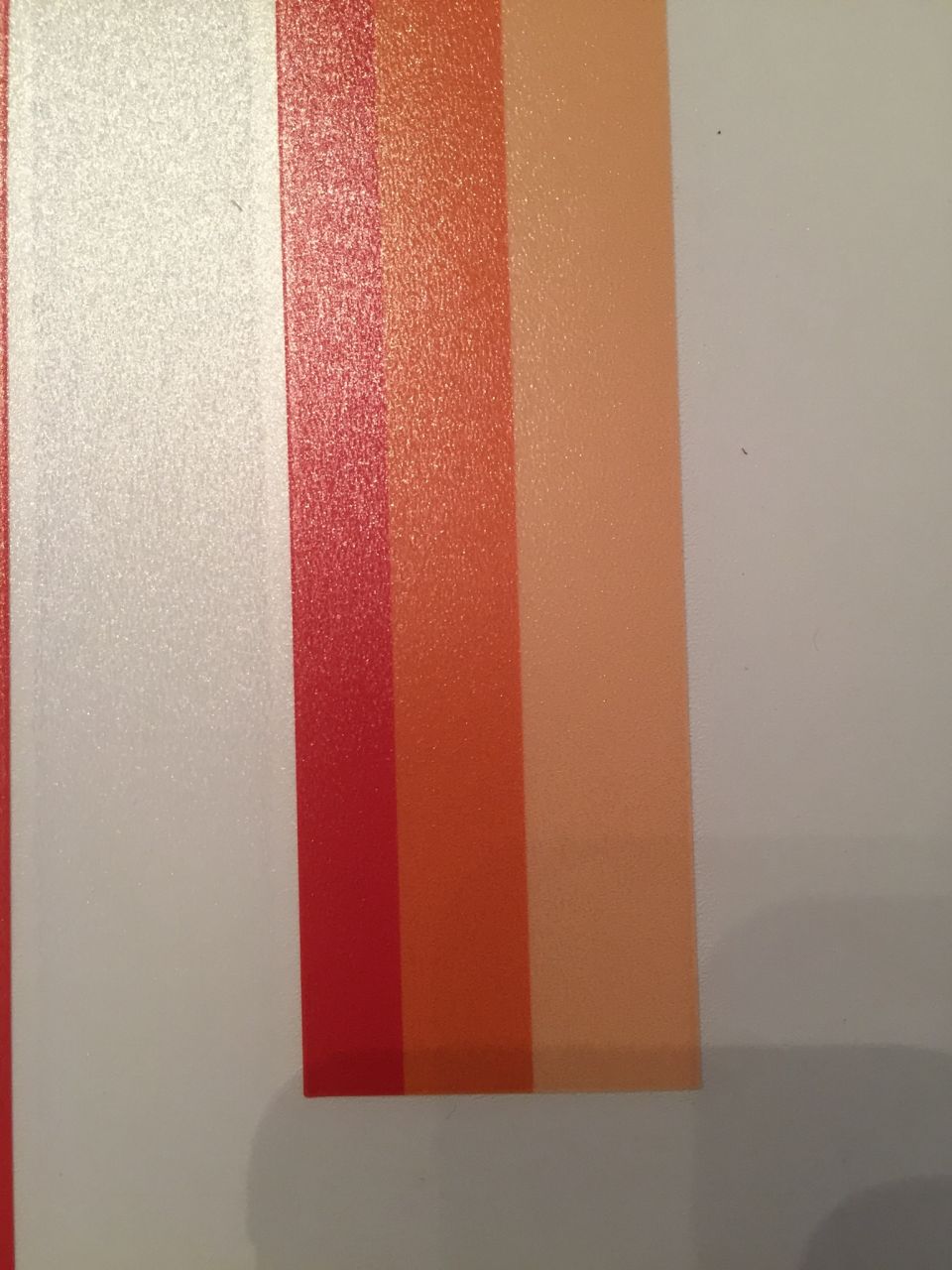 close-up of a white, red, orange, and peach stripe decal