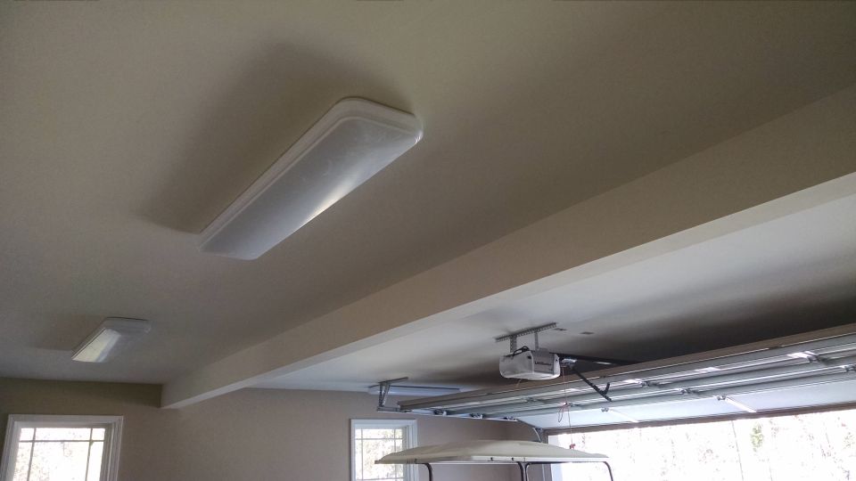 The garage will be well-lit with 4 of these 4-foot LEDs from Sam's, and the opener's light.  The front 2 are beside the door, so it doesn't block them.