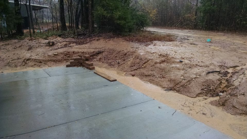 The concrete crew left a depression in the existing bank that allowed a torrent from the high ground to erode onto the patio.  The landscapers are coming to fix it, when the ground dries out some.