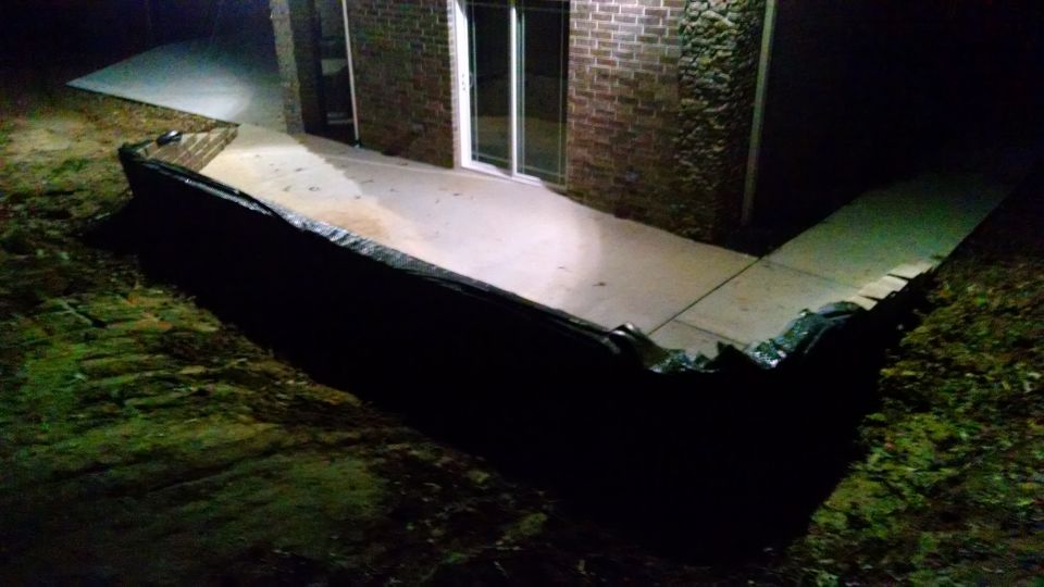 I added 3 layers of fabric to keep dirt from oozing through, and a french drain (hidden in the shadow) to carry the water away.