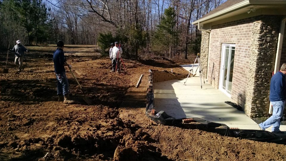 The landscapers are carefully adjusting the grade for the runoff that I want, before planting the shrubs here.