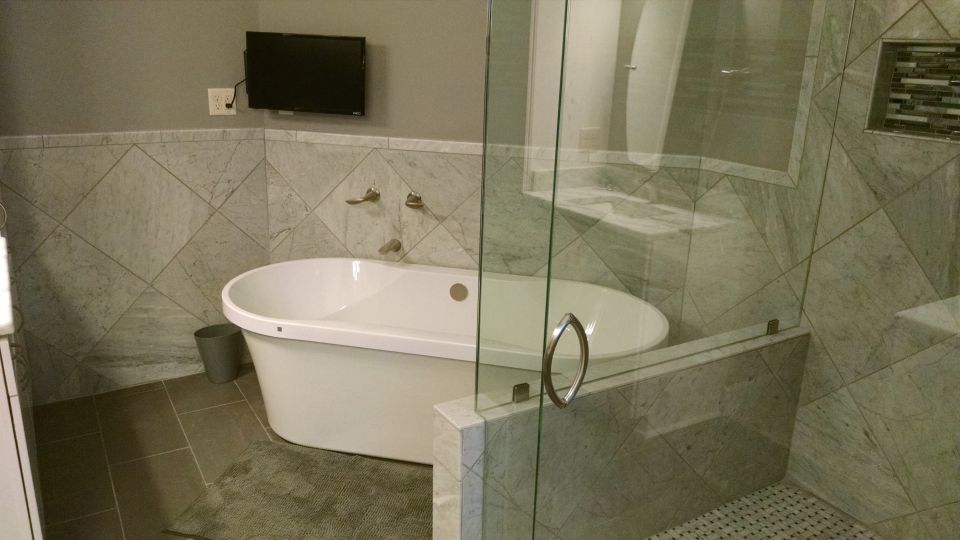 Her indoor swimming pool with TV that she can see from her vanity, too.  The ledge beside the shower glass is for her tub accessories.