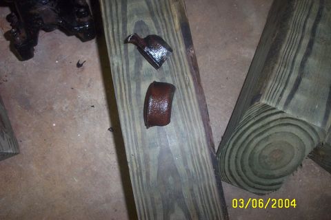 1979 Ford F-150 - Close-up of two small, rusted metal components resting on a wooden plank.