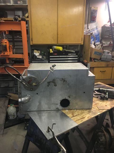 1961 International Scout 800 - Metal fuel tank with various fittings and ports, resting on sawhorses in a workshop.