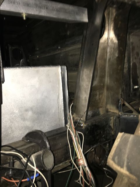 1961 International Scout 800 - Close-up view of a metal tank and wiring harness within a vehicle's chassis.