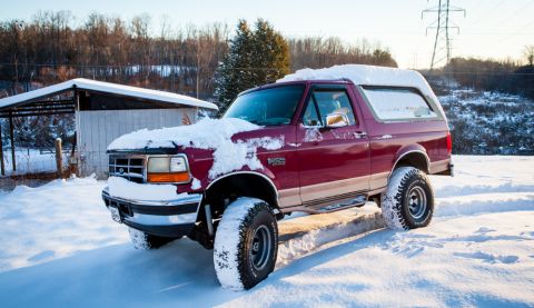 1995 Ford Bronco - This 1995 Ford Bronco is parked in a snowy landscape, with snow covering its hood and roof.