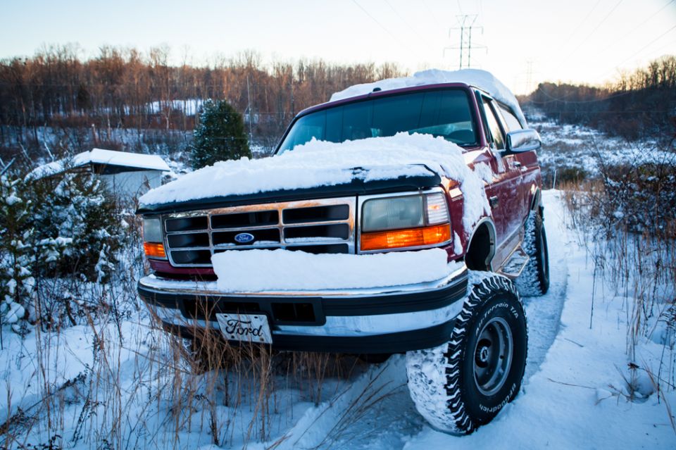 Red 1995 Ford Bronco in snow, front 3/4 view