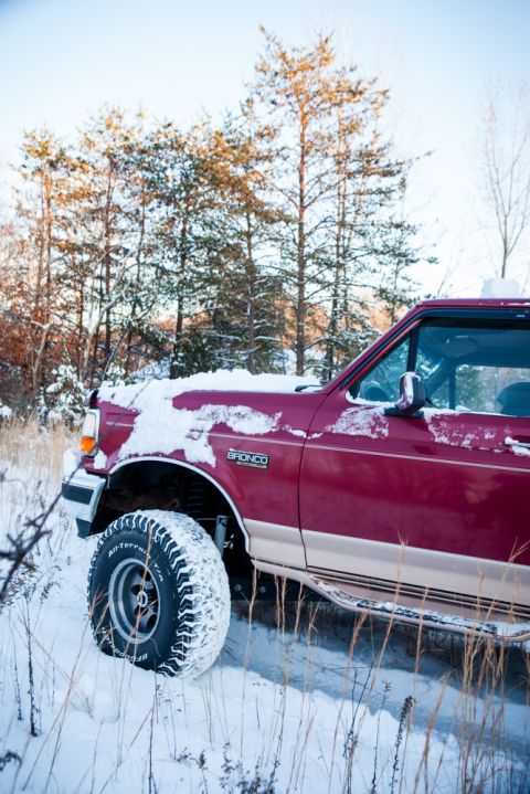 1995 Ford Bronco - 1995 Ford Bronco navigating a snowy landscape with snow covering its front.