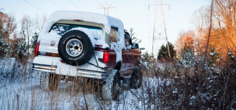 1995 Ford Bronco - A 1995 Ford Bronco navigates a snowy, wooded terrain.