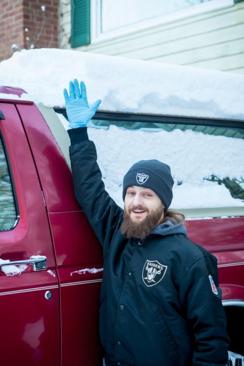 1995 Ford Bronco - Man in Raiders gear waves from his 1995 Ford Bronco during a snowy day.