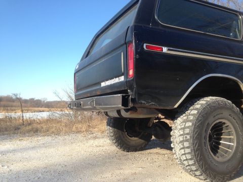 1979 Ford Bronco - Rear view of a black 1979 Ford Bronco a custom bumper and off-road tires.