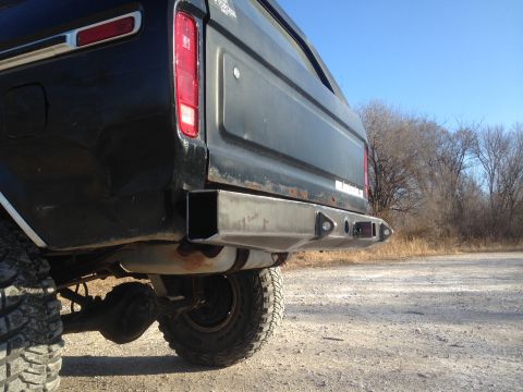 1979 Ford Bronco - Custom rear bumper on a black SUV, showing the exhaust and tire.