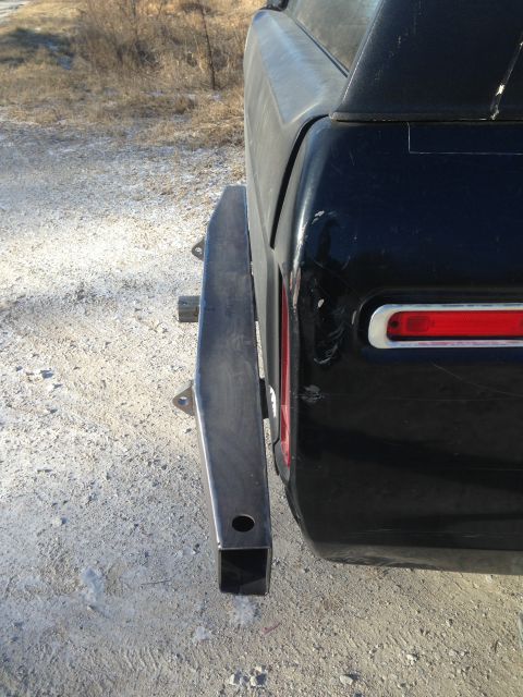 1979 Ford Bronco - A custom rear bumper is shown attached to the back of a black SUV, with a dirt lot in the background.