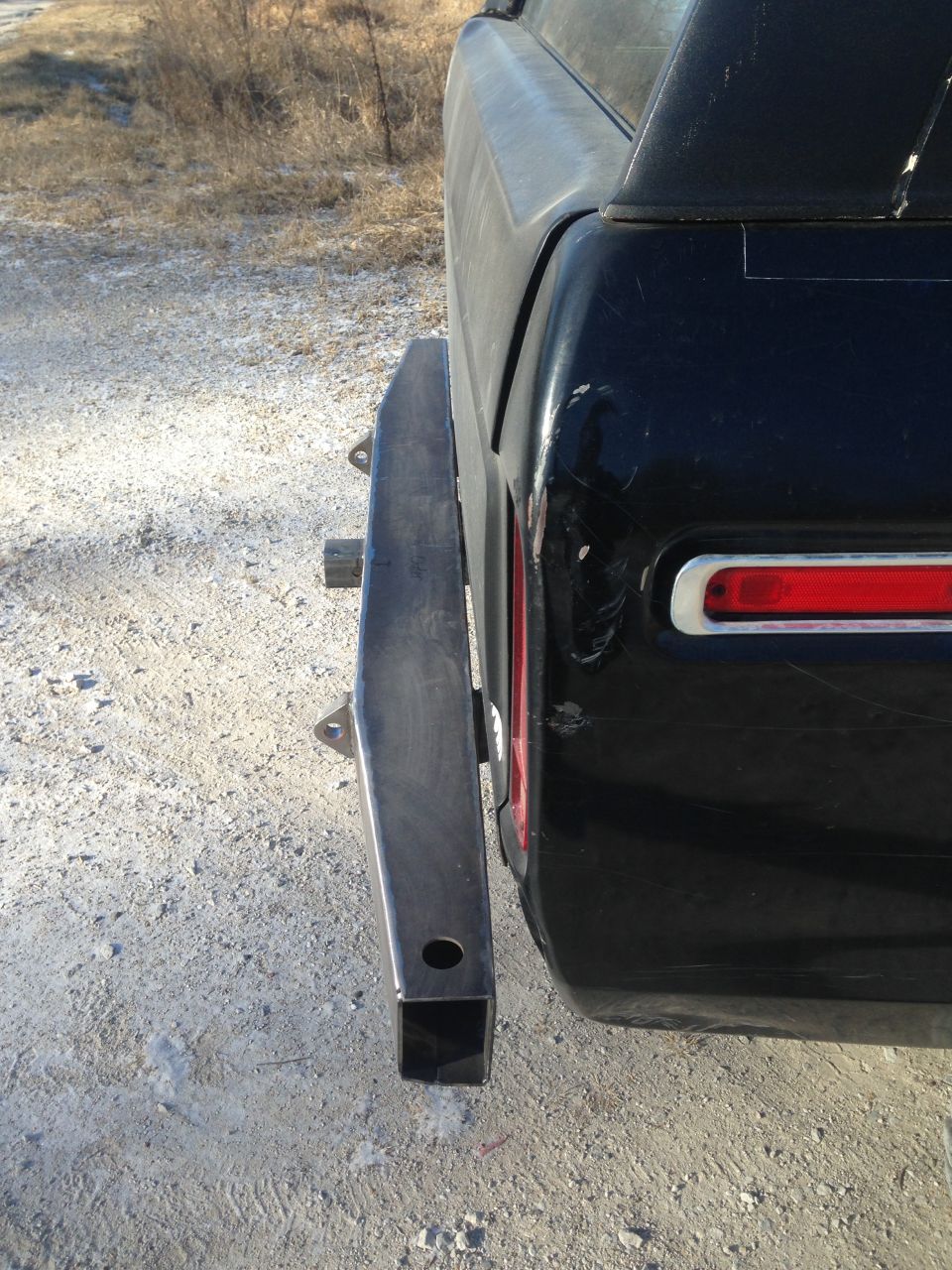 Black SUV's rear corner with a custom fabricated bumper attached