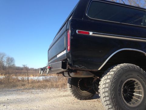 1979 Ford Bronco - Rear view of a black 1979 Ford Bronco a custom bumper and off-road tires.