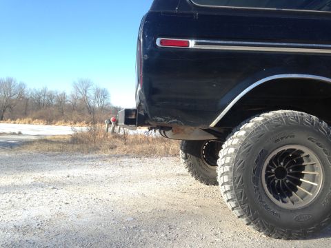 1979 Ford Bronco - Rear view of a dark SUV, showing its bumper and tire. The body style suggests a late 1970s model.
