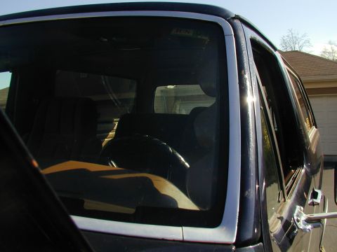 1988 Ford Bronco - View of the interior of a vehicle, including the steering wheel and seats, from an exterior perspective.