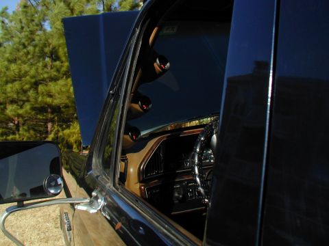 1988 Ford Bronco - Interior view of a black SUV, showing aftermarket gauges on the A-pillar and a tan dashboard.