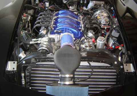 1976 Chevrolet Corvette - The engine bay features a custom intake system with a prominent blue intake manifold and a large air filter.