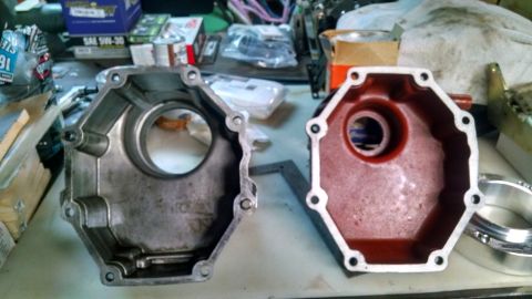 1985 Jeep CJ7 - Two octagonal metal covers, one showing wear and the other painted red, sit on a cluttered workbench.
