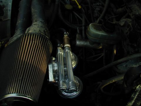 1988 Ford Bronco - Close-up of engine bay components including an air filter and fuel lines.
