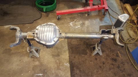 1994 Ford Bronco - Rear axle assembly, likely for a Ford Bronco, is supported by jack stands in a workshop setting.