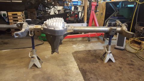 1994 Ford Bronco - Rear axle assembly for a Ford Bronco, supported by jack stands in a workshop.