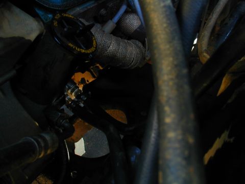 1988 Ford Bronco - Close-up view of engine bay components, including hoses and wrapped metal parts.