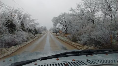 1985 Ford Bronco - Driving through a winter wonderland with ice-covered trees lining the road.