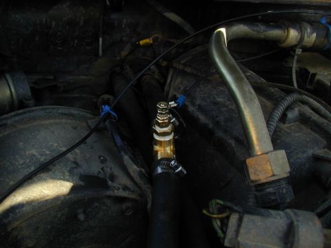 1988 Ford Bronco - Close-up of engine bay components, including a brass fitting on a hose.