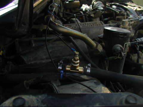 1988 Ford Bronco - A brass valve has been added to a hose in the engine bay, with electrical connections attached.